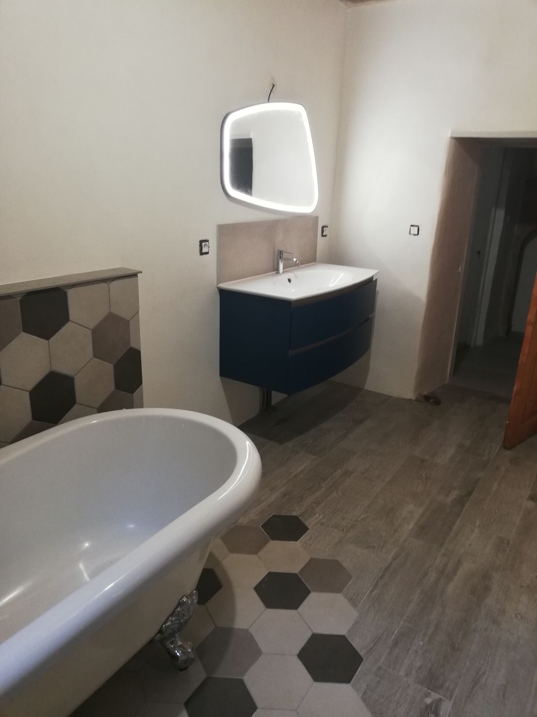 Salle de bain rénovée — douche à l'italienne spacieuse, baignoire îlot conservée, matériaux pierre et bois — Vallée d'Azergues